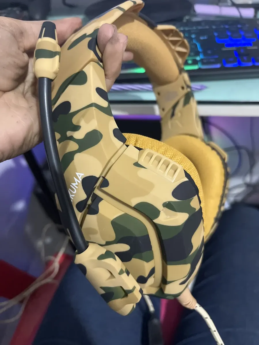 Cliente exibindo o Headset Gamer Onikuma K1-B camuflado amarelo fora da caixa